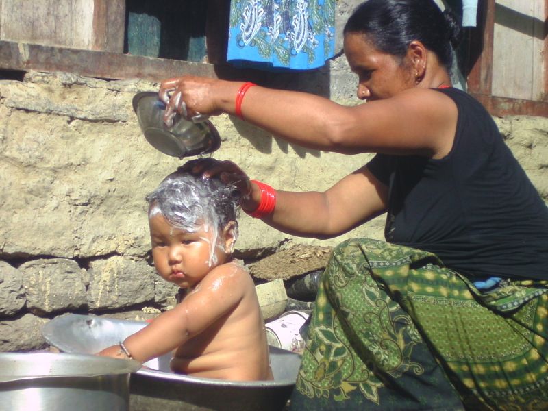 femme lavant son enfant au Nepal